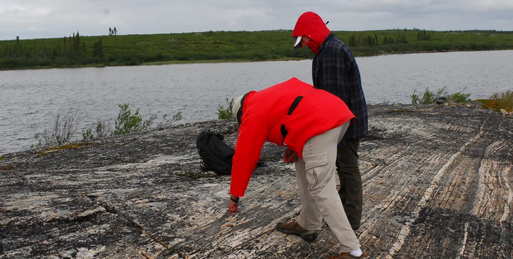 Two scientist studying an outdrop of gneiss in Northwest Territories, Canada